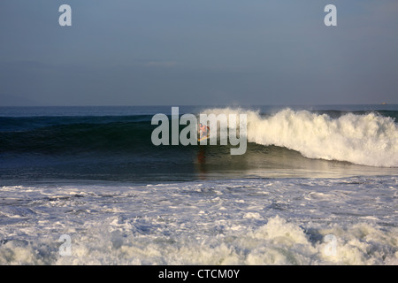 Corpo uomo surf una grande onda nel West Java, Indonesia. Foto Stock