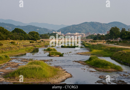Looking south along the peaceful Kamo River (Kamo-gawa) towards the city centre of Kyoto, Japan, and the surrounding hills Foto Stock