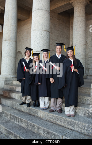 Ridendo laureati ponendo il pollice-up Foto Stock