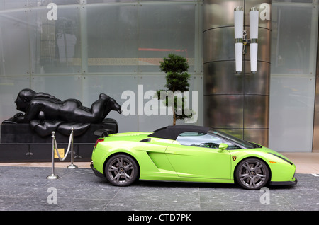 Verde Lime Lamborghini auto e parcheggiata accanto a una scultura dell'artista colombiano Fernando Botero. Foto Stock