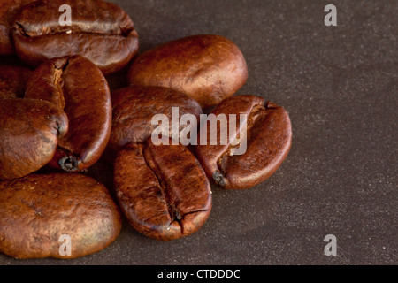 I semi di caffè stabiliti insieme su una tavola nera Foto Stock