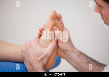 Podiatrist praticare la riflessologia del piede della donna Foto Stock