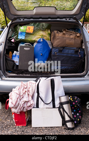 Famiglia in vacanza con la loro automobile impaccata con valige, borse, coperte e altro ancora Foto Stock