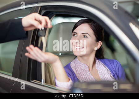 Donna sorridente mentre è seduto in un auto Foto Stock