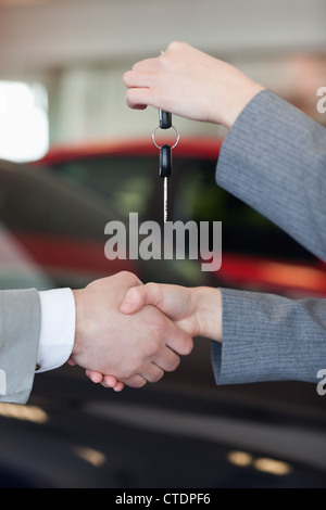 In prossimità di una donna che dà le chiavi dell'auto per un uomo Foto Stock