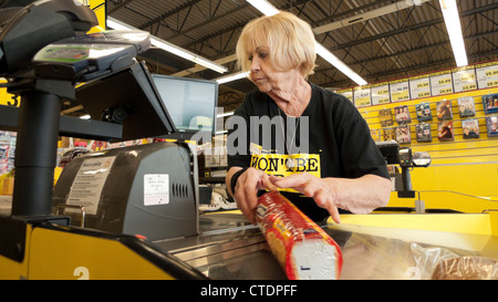 Un senior impiegato femminile pensionato lady 70s lavorare in cassa in Jesse & Kelly senza fronzoli supermercato store Canada KATHY DEWITT Foto Stock