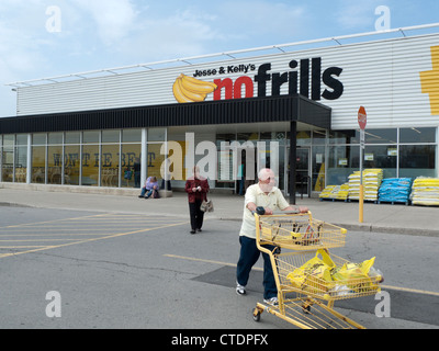 Un uomo anziano spingendo un carrello della spesa al di fuori di Jesse & Kelly senza fronzoli supermercato store Ontario, Canada, America del Nord Foto Stock