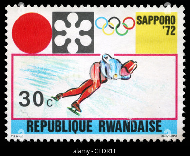 Ruanda - circa 1972: un timbro stampato in Ruanda mostra Sapporo emblema Olimpico e la pratica del pattinaggio di velocità, circa 1972 Foto Stock