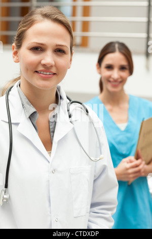 Dottore in piedi in un ospedale reception con un infermiere Foto Stock