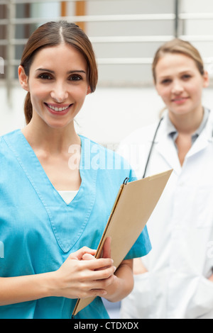 L'infermiera in piedi in un ospedale reception con un medico Foto Stock