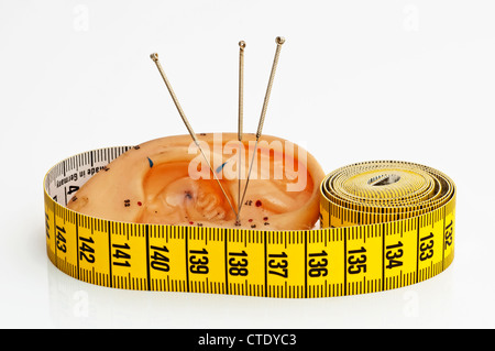 Modello di orecchio con aghi di agopuntura e misurare Foto Stock