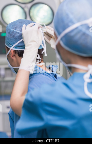 Close up di un infermiere legatura di una maschera di un medico Foto Stock