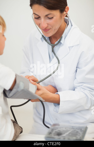 Medico la misura della pressione del sangue di un bambino Foto Stock