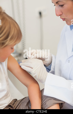 Medico inietta il liquido in un braccio del bambino Foto Stock