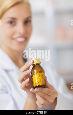 Il farmacista che mostra un flacone di farmaco Foto Stock