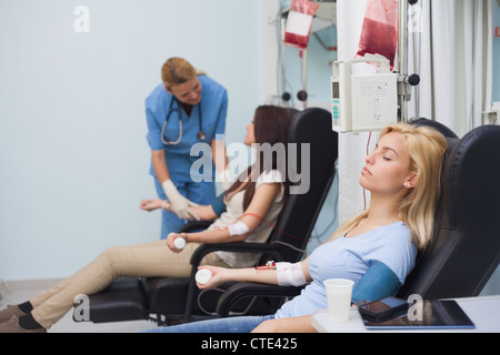 Infermiere di prendersi cura di un donatore di sangue Foto Stock