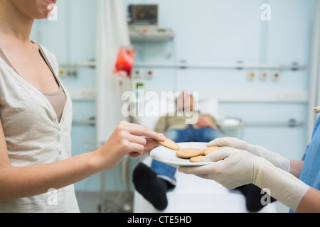 Infermiere dare biscotti ad un donatore Foto Stock