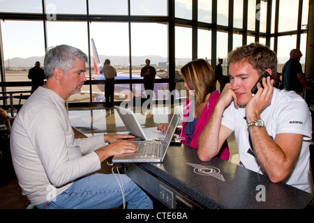 Le persone utilizzano internet wi-fi presso l'Aeroporto Internazionale Sky Harbor di Phoenix si trova nella città di Phoenix, Arizona, Stati Uniti. Foto Stock