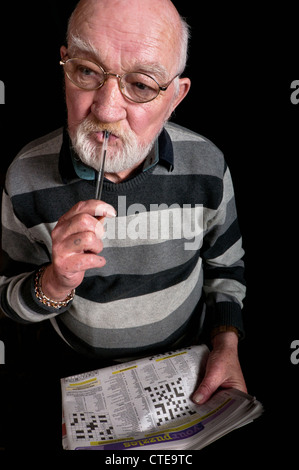 Uomo in pensione facendo un cruciverba Foto Stock