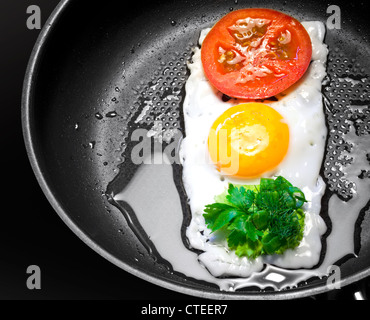 Colazione originale tema. Uova fritte con pomodoro e verdure in forma di semaforo in padella Foto Stock