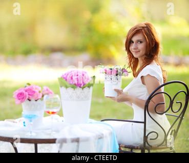 Ritratto di giovane e bella donna con vaso di fiori in mani Foto Stock