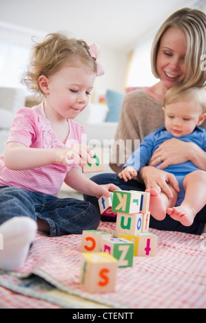 Stati Uniti d'America, New Jersey, Jersey City, Madre a giocare con i bambini (2-3, 6-11 mesi) a casa Foto Stock