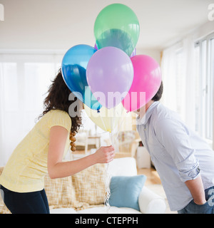 Stati Uniti d'America, New Jersey, Jersey City, giovane kissing dietro il mucchio di palloncini colorati Foto Stock