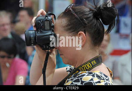 Donna che utilizza una Nikon D700 Fotocamera reflex digitale per scattare fotografie con la torcia olimpica evento in Lewes 17 Luglio 2012 Foto Stock