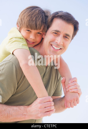 Stati Uniti d'America, New Jersey, Jersey City, Padre dando il suo figlio (10-11 anni) piggyback ride Foto Stock