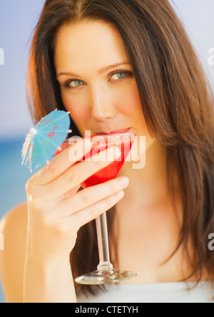 Ritratto di giovane donna con cocktail, studio shot Foto Stock