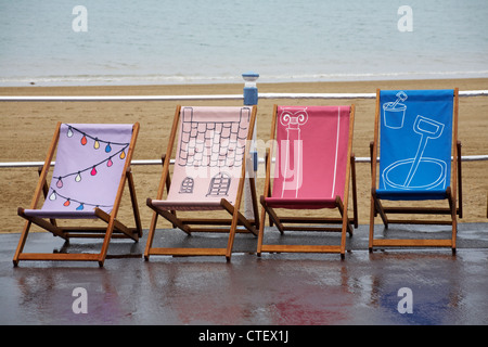 Weymouth Esplanade è decorato con 500 sedie a sdraio, sedie a sdraio, progettato dalla gente del posto a Weymouth Beach, Dorset UK in una giornata piovosa bagnata nel mese di luglio Foto Stock