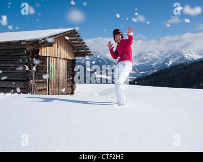 Austria, Maria Alm, Donna alla cima della montagna godendo lotta con le palle di neve Foto Stock