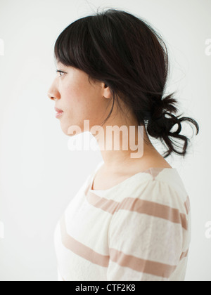 Vista laterale della giovane donna, studio shot Foto Stock