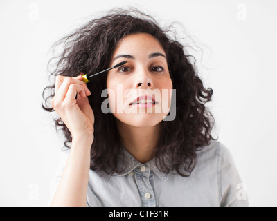 Bella giovane donna applicazione di mascara Foto Stock
