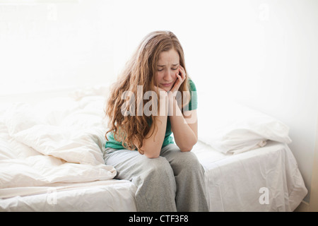 Stati Uniti d'America, Utah, Salt Lake City, triste giovane donna seduta a letto Foto Stock