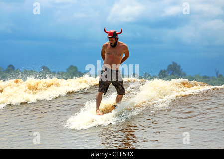 Man River surfing una marea di onda del foro sul fiume Kampar, conosciuto localmente come Bono e chiamato i 7 Fantasmi da stranieri di surfers. Foto Stock