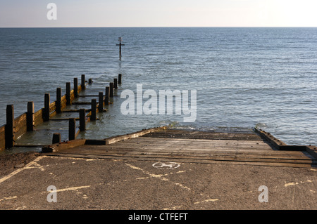 Scalo per la spiaggia e il mare ad alta marea a Walcott, Norfolk, Inghilterra, Regno Unito. Foto Stock
