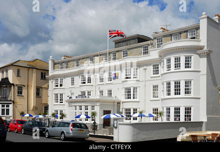 Devon - Sidmouth - l imponente facciata bianca della Riviera Hotel -sull'Esplanade - battenti bandiera dell'Union Jack - la luce del sole e SHA Foto Stock