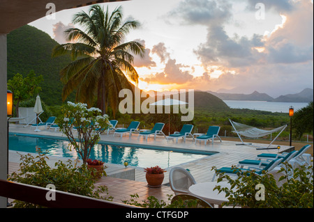 Caribbean West Indies Nevis Mount Nevis Hotel piscina al tramonto con una vista di Saint Kitts - Sera Foto Stock