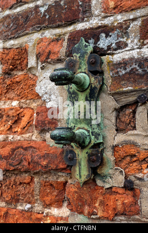 Parte di un corroso porta vecchia cerniera su un muro di mattoni parte della vecchia canonica Beaconsfield Bucks REGNO UNITO Foto Stock