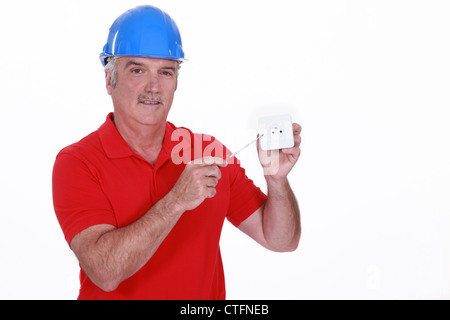 Elettricista con presa di corrente a muro Foto Stock