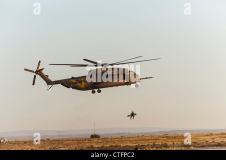 Una forza aerea israeliana CH-53 elicottero durante la ricerca e il salvataggio di formazione, tirando verso l'alto un medic con un 'vittima' su una barella. Foto Stock
