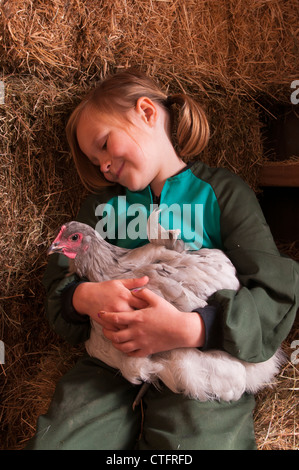 Ragazza giovane alimentazione di polli a una capanna di pollo su un blocco di lifstyle, appena fuori Raglan, Nuova Zelanda Foto Stock