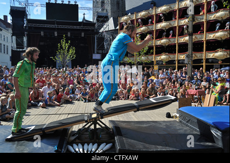 Pubblico guardando gli artisti di strada che mostra agire con altalena a Gentse Feesten / Gand Festeggiamenti in estate, Belgio Foto Stock