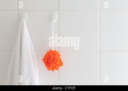 Attaccato,bagno,CERAMICA,pulito,spugnette,boiacca,intonacato,Casa,ganci,arancione,plastica,doccia,square,corde,tiles,asciugamano,wall,bianco Foto Stock