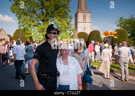 Funzionario di polizia e una signora che posano per una foto dopo la torcia olimpica Painswick, Gloucestershire Foto Stock