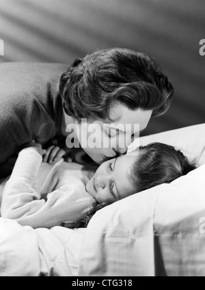 Anni Cinquanta madre figlia dando una buona notte bacio Foto Stock