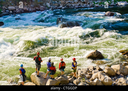 Famiglia caucasica in piedi vicino a rapide nel fiume Foto Stock