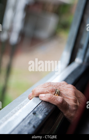 Old Lady la mano in corrispondenza della finestra sul treno in Sri Lanka Foto Stock