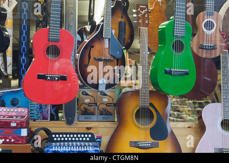 Killarney, nella contea di Kerry, Irlanda. Gli strumenti a corda in vendita in vetrina. Chitarre e Mandolini, ukuleles. Foto Stock